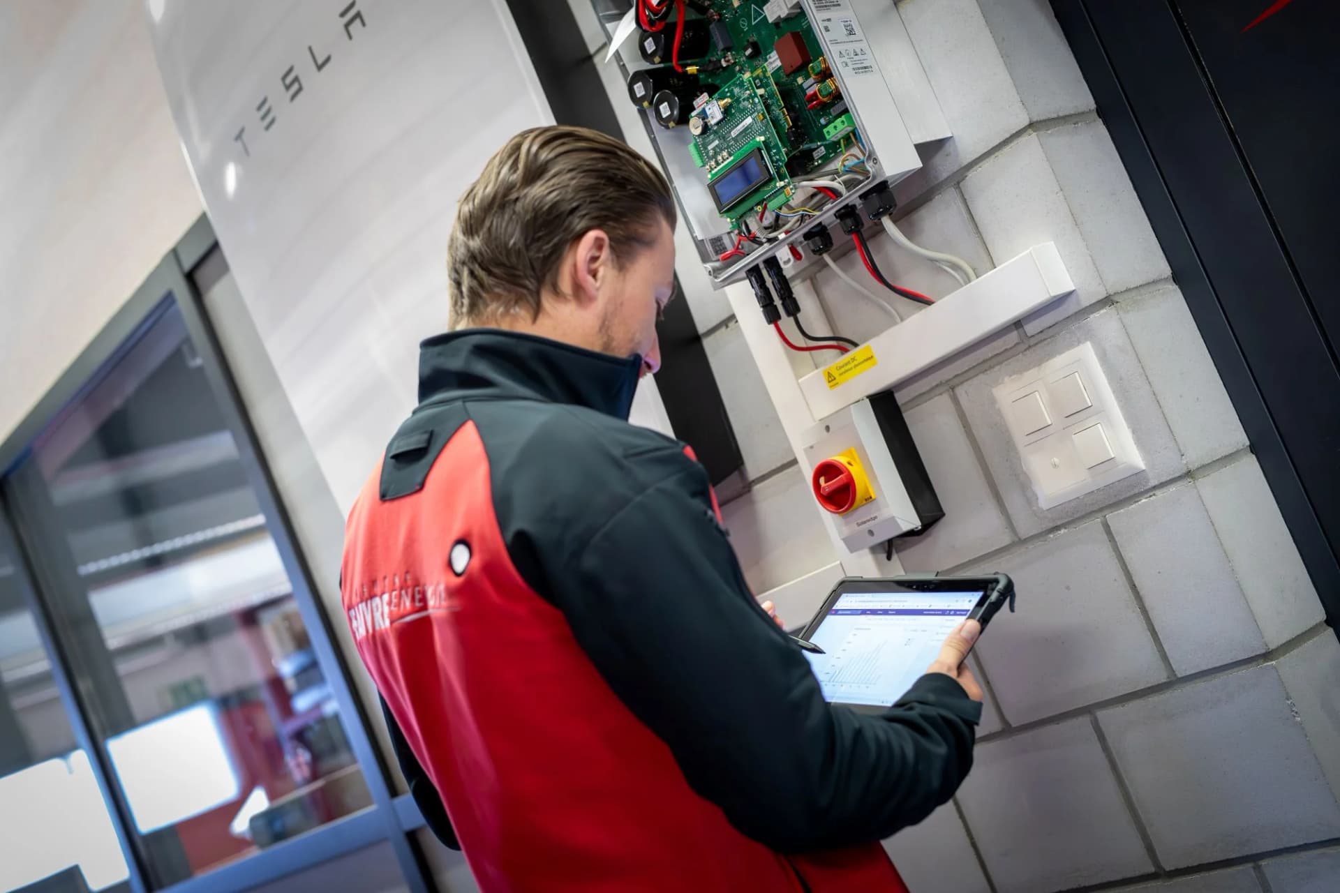 Technicien Faivre Energie configurant un tableau électrique Tesla